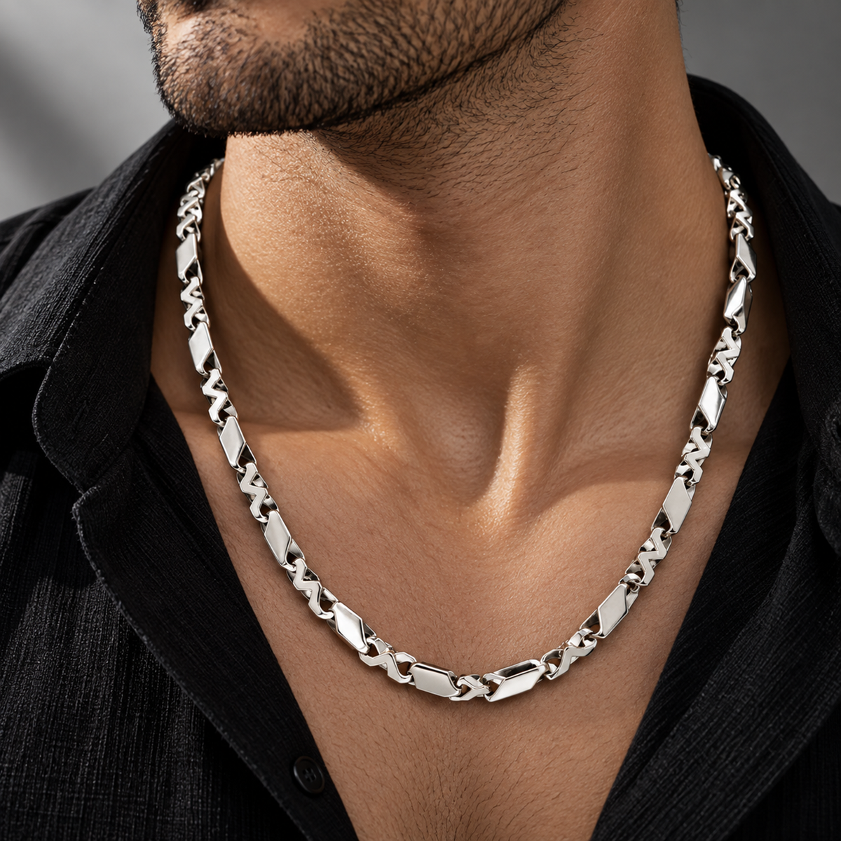 Men’s platinum chain featuring a geometric interlocking link design worn on a male model