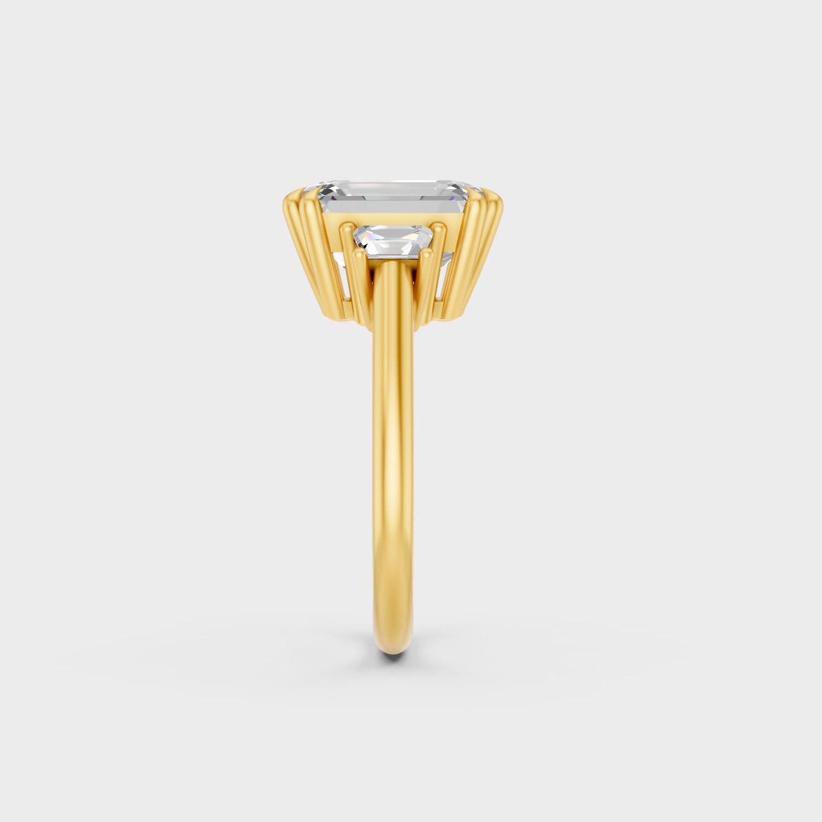 Close-Up View of 4.28 Ct Emerald and Baguette Lab-Grown Diamond Three-Stone Ring with warm 18K Yellow Gold band.