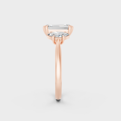 Stunning 3.14 Carat Emerald and Marquise-Cut Lab-Grown Diamond Three-Stone Ring in a 14K Rose Gold setting.