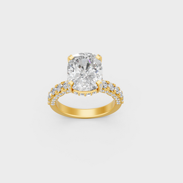 Close up detail of cushion center stone and round accent diamonds on yellow gold band