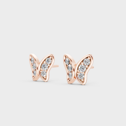 Pair of Ethical Luxury Diamond Butterfly Studs glowing on a rose-hued 18K Rose Gold Setting.