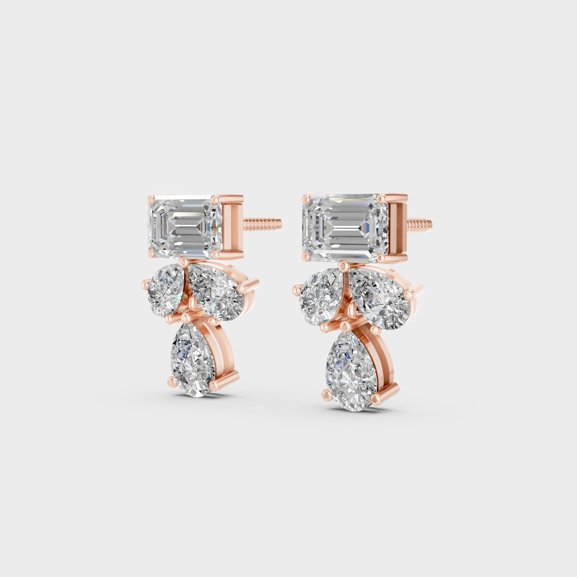 Pair of Ethical Luxury Emerald and Pear Diamond Studs glowing on a rose-hued 18K Rose Gold Setting.
