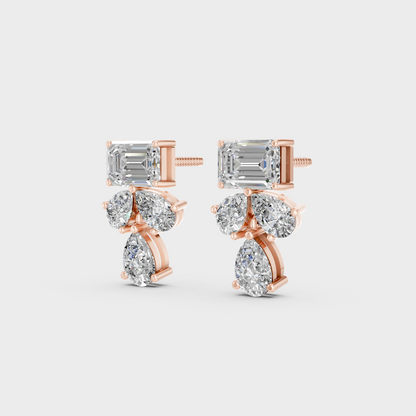 Pair of Ethical Luxury Emerald and Pear Diamond Studs glowing on a rose-hued 18K Rose Gold Setting.