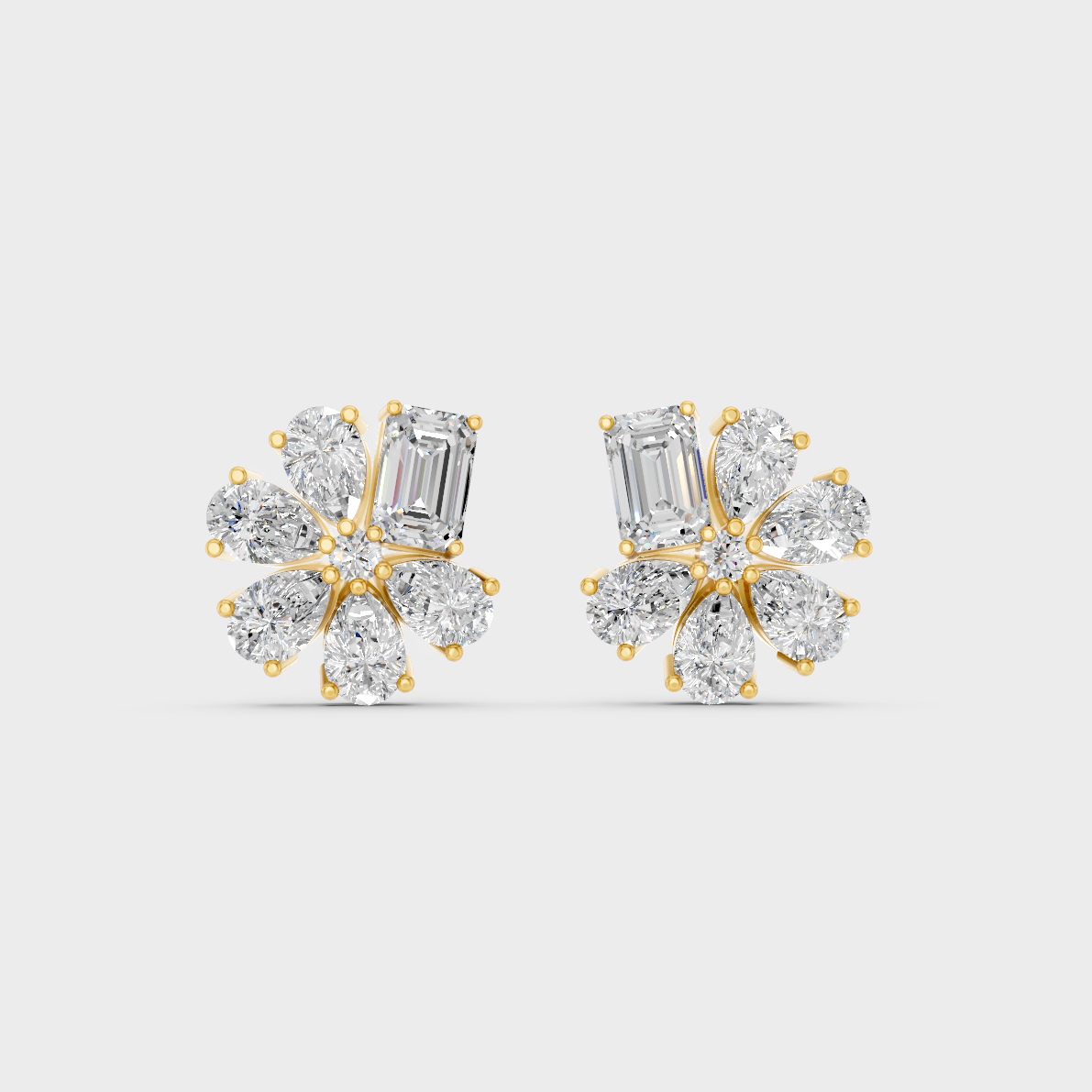 On-model ear wearing a pair of 2.46ct Emerald and Pear Lab Diamond Stud Earrings in classic 9K Yellow Gold.
