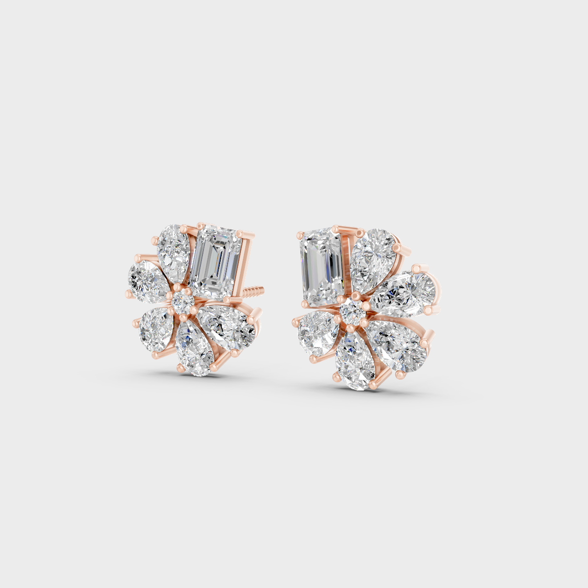 Pair of Ethical Luxury Emerald and Pear Diamond Studs glowing on a rose-hued 18K Rose Gold Setting.