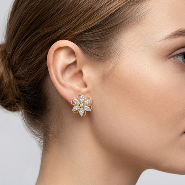 Model wearing a yellow gold floral bloom stud earring featuring marquise-cut diamond petals interspersed with delicate gold wire loops around a center round diamond, shown close-up on the earlobe.