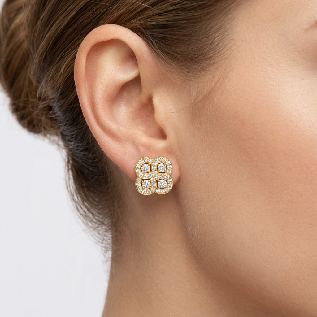 Model wearing a yellow gold four-cluster quatrefoil stud earring featuring four interlocking round diamond clusters with pavé halos, shown close-up on the earlobe.