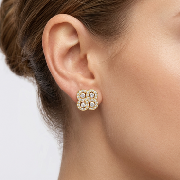 Model wearing a yellow gold four-cluster quatrefoil stud earring featuring four interlocking round diamond clusters with pavé halos, shown close-up on the earlobe.