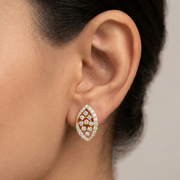Model wearing a yellow gold marquise-shaped stud earring featuring a diamond grid center framed by a pavé diamond halo border, shown close-up on the earlobe.