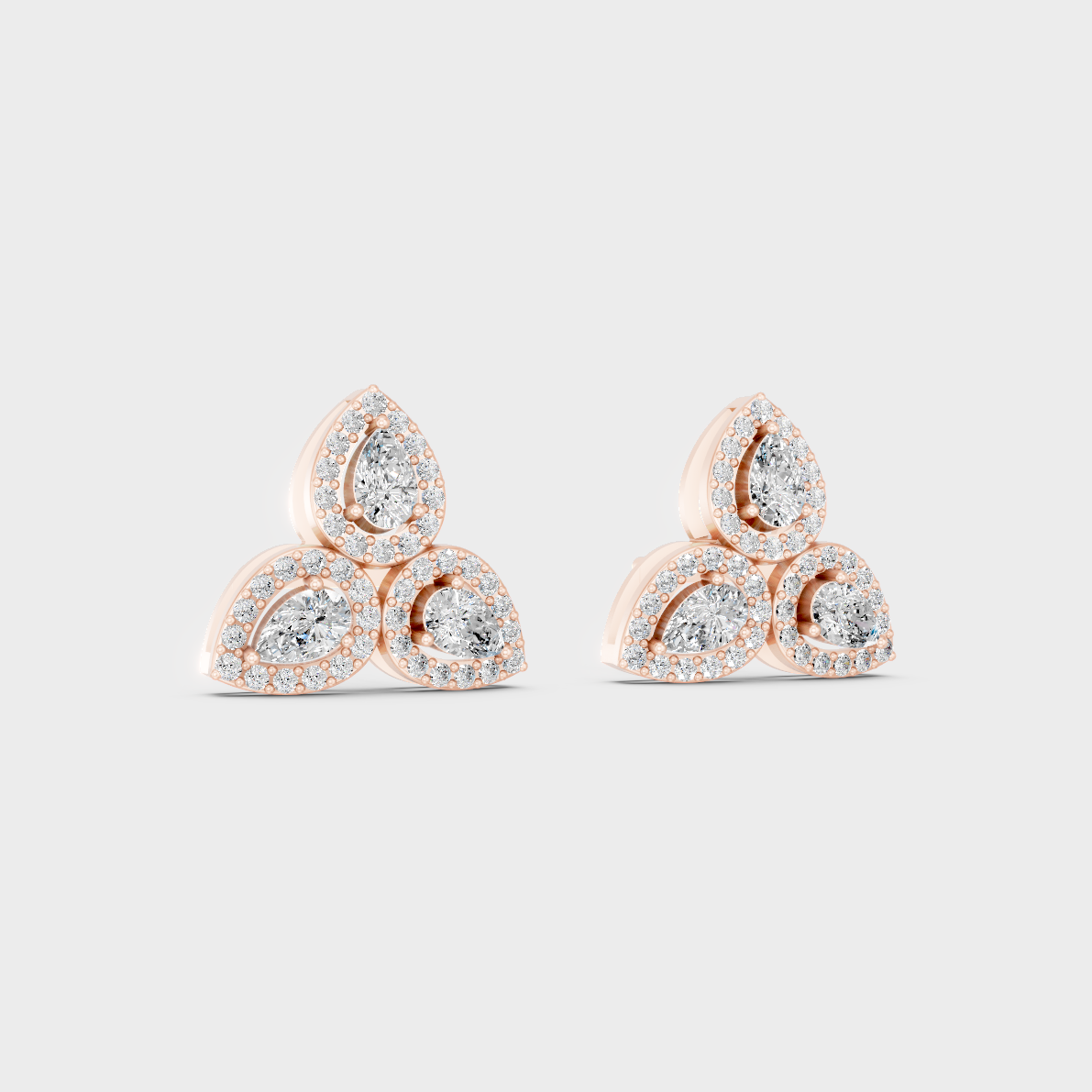 Pair of Ethical Luxury Round and Pear Diamond Studs glowing on a rose-hued 18K Rose Gold Setting.