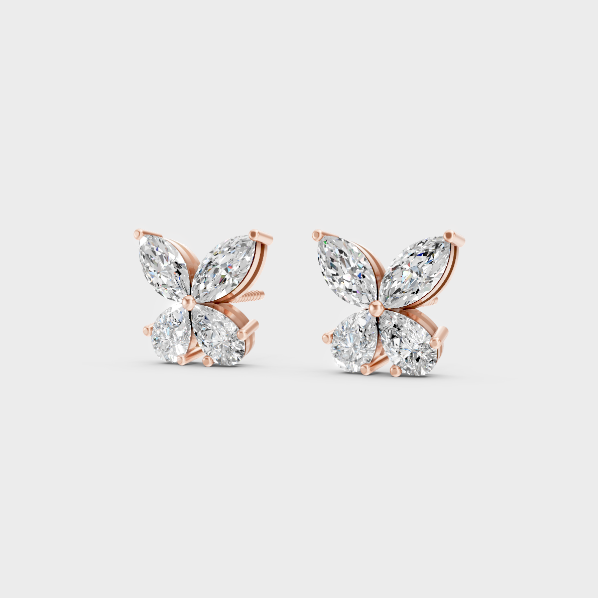 Pair of Ethical Luxury Marquise and Pear Diamond Studs glowing on a rose-hued 18K Rose Gold Setting.